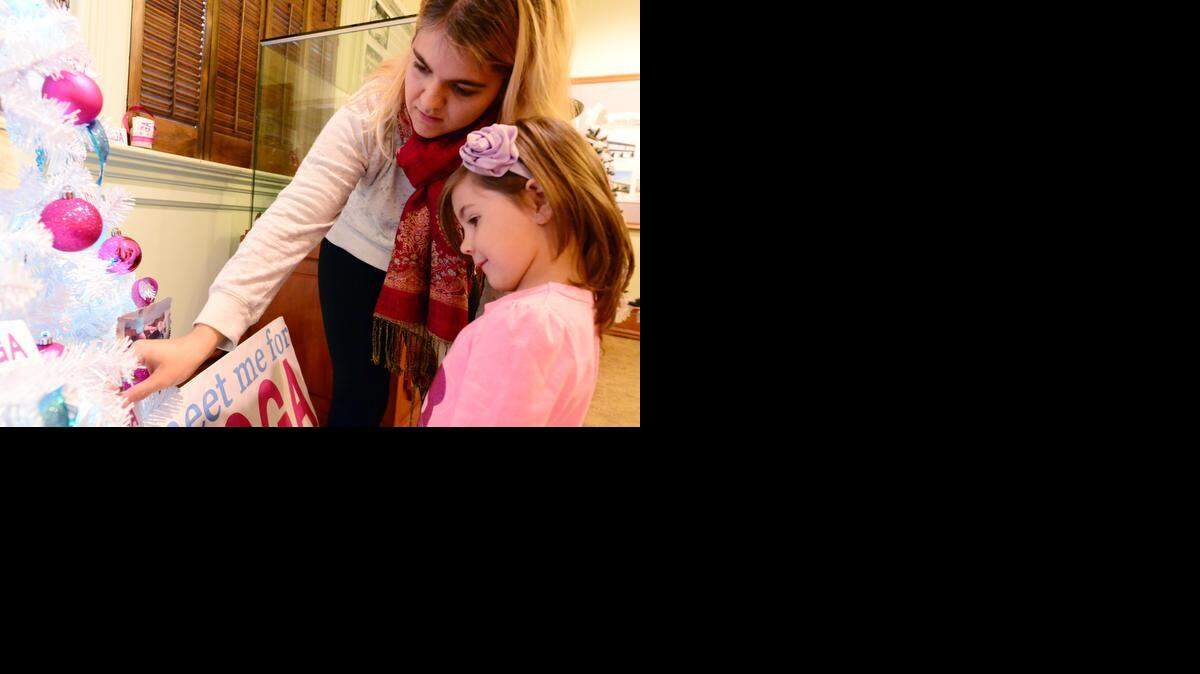 
Danaelle Rodriguez, 29, of Merced shows ornaments to 4-year-old Kara Rieg at the Merced County Courthouse Museum on Monday. 
