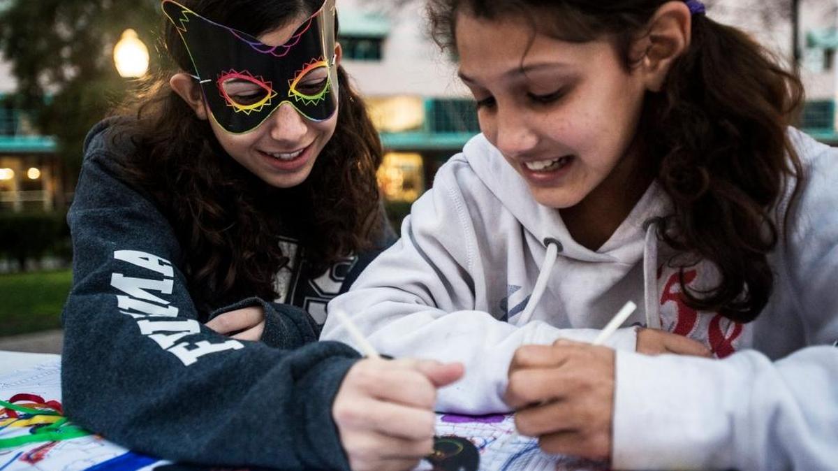 Rebekah Friedman, 14, left, of Merced, helps Breanna Worthen, 11, of Merced, right, decorate a mask during the Merced Art Hop in Merced, Calif., Saturday, Jan. 16, 2016.