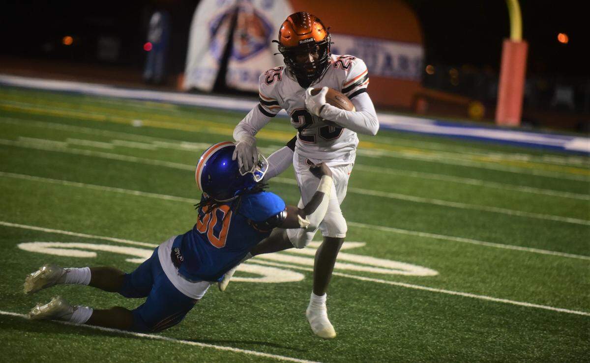 Merced High running back Chase Smith (25) stiff arms Kimball defender Jerome Nance III during the Bears’ 51-50 win over the Jaguars on Friday, Nov. 19, 2021 at Kimball High School in Tracy, Calif.
