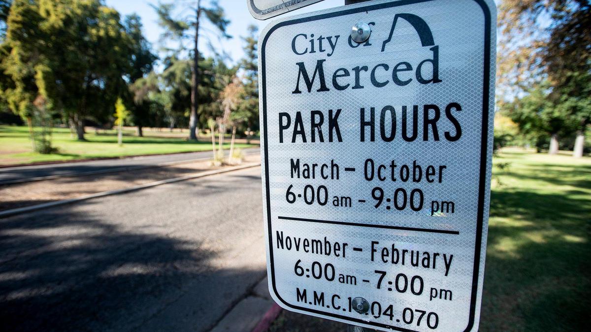 Park hours are displayed on a sign at Applegate Park, located at West 25th and R streets in Merced, Calif., on Thursday, Sept. 2, 2021.
