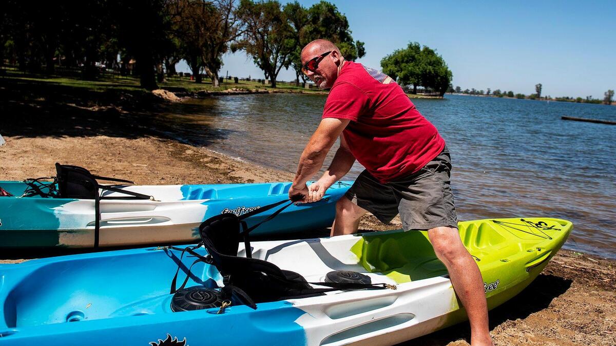 Mark Anderson, owner of The Padyak Shack, prepares a kayak for use at Lake Yosemite in Merced, Calif., on Thursday, May 21, 2020.