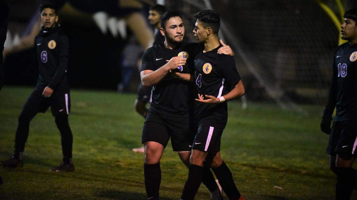 Livingston High senior Gerardo Casto (left) talks to teammate Ezekiel Padilla after Padilla received his second yellow card after celebrating his goal against Dixon in a playoff match on Tuesday, Feb. 15, 2022 in Livingston, Calif.