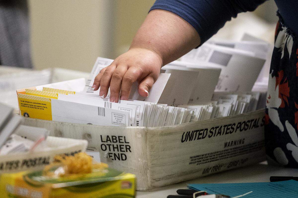 An election worker looks through a tray of ballots sealed in envelopes at the Merced County Elections Warehouse in Merced, Calif., on Tuesday, Nov. 5, 2024.