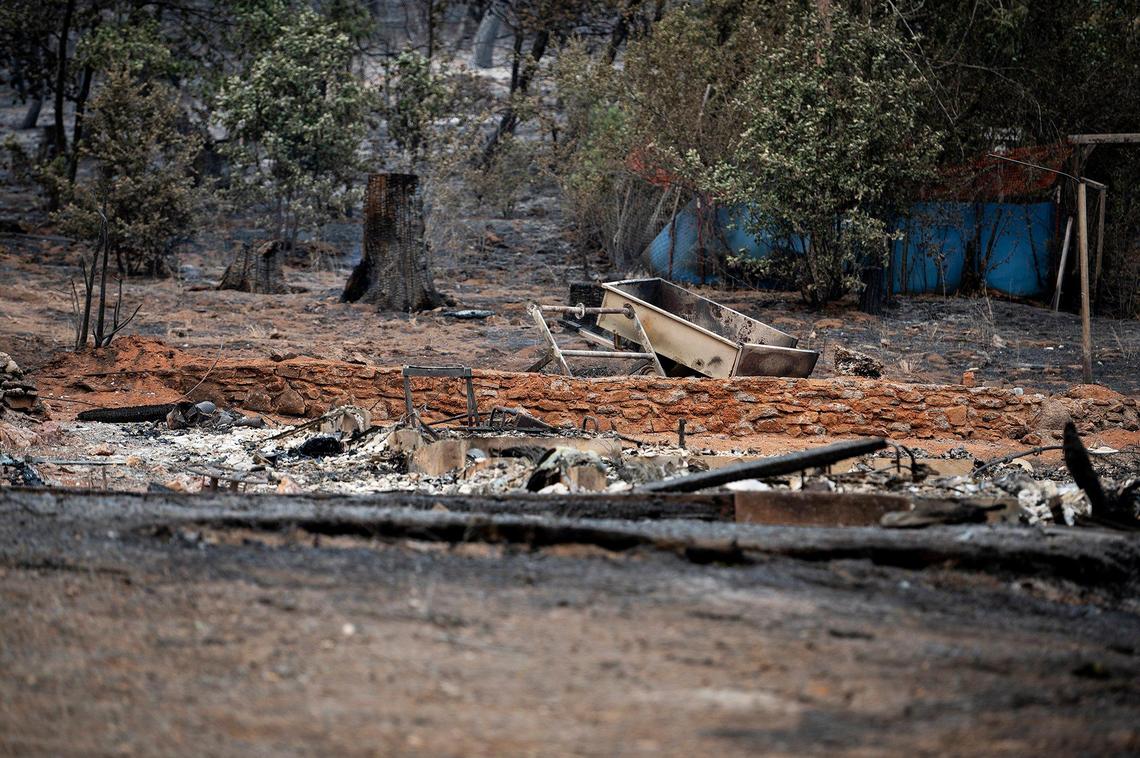 Charred items on a property along Jerseydale Road as firefighters continue to battle the Oak Fire in Mariposa County, Calif., on Tuesday, July 26, 2022.