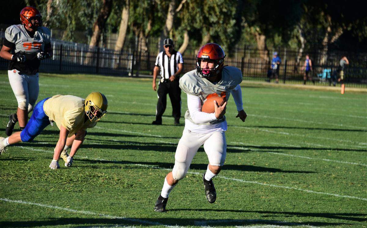 Merced High School quarterback Carter Haugen runs the ball during a scrimmage against Clovis on Friday, Aug. 12, 2022 at Cathie Hostetler Stadium in Merced, Calif.