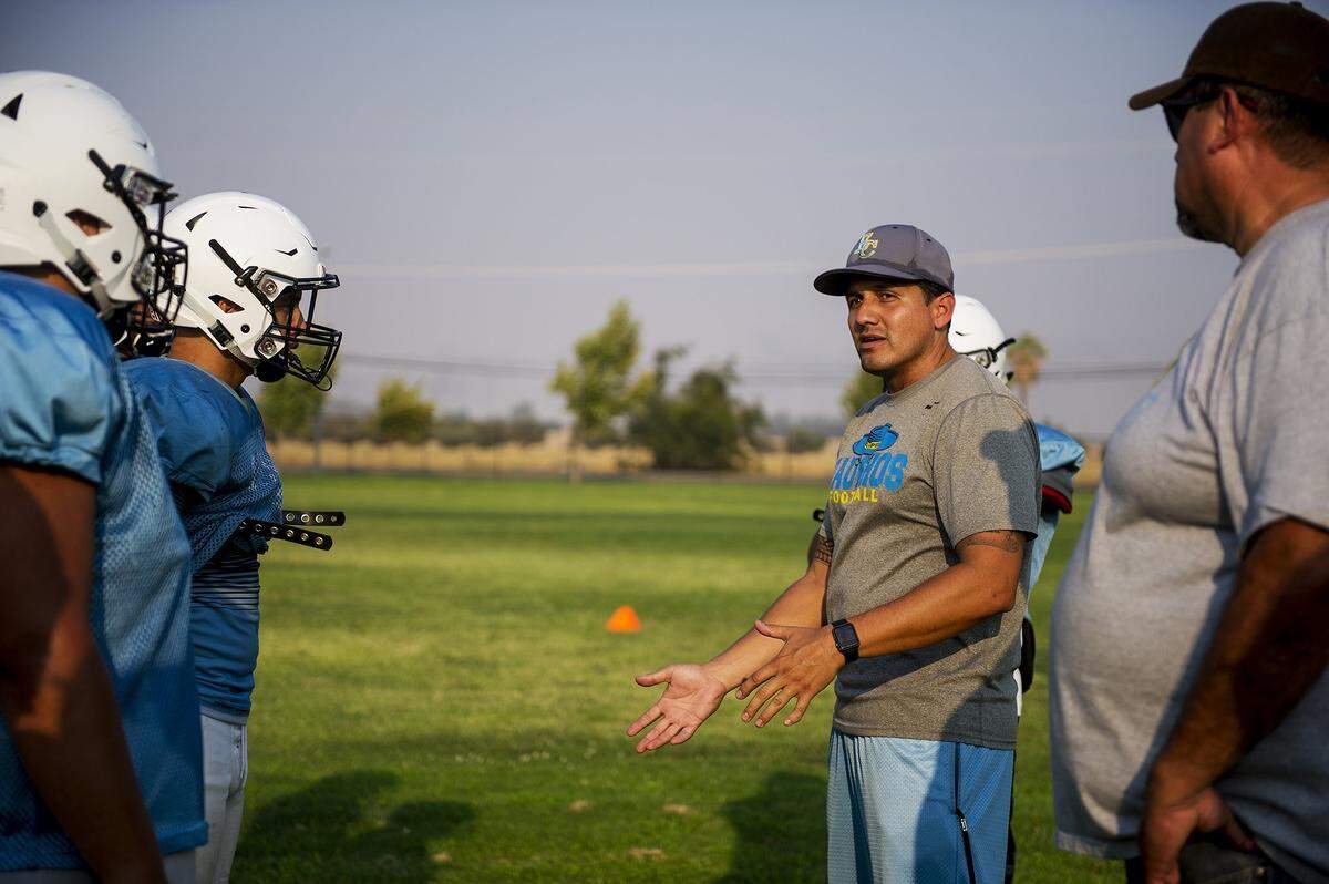 Head coach Frank Solis speaks to players during football practice at El Capitan High School in Merced, Calif., on Wednesday, Aug. 8, 2018.