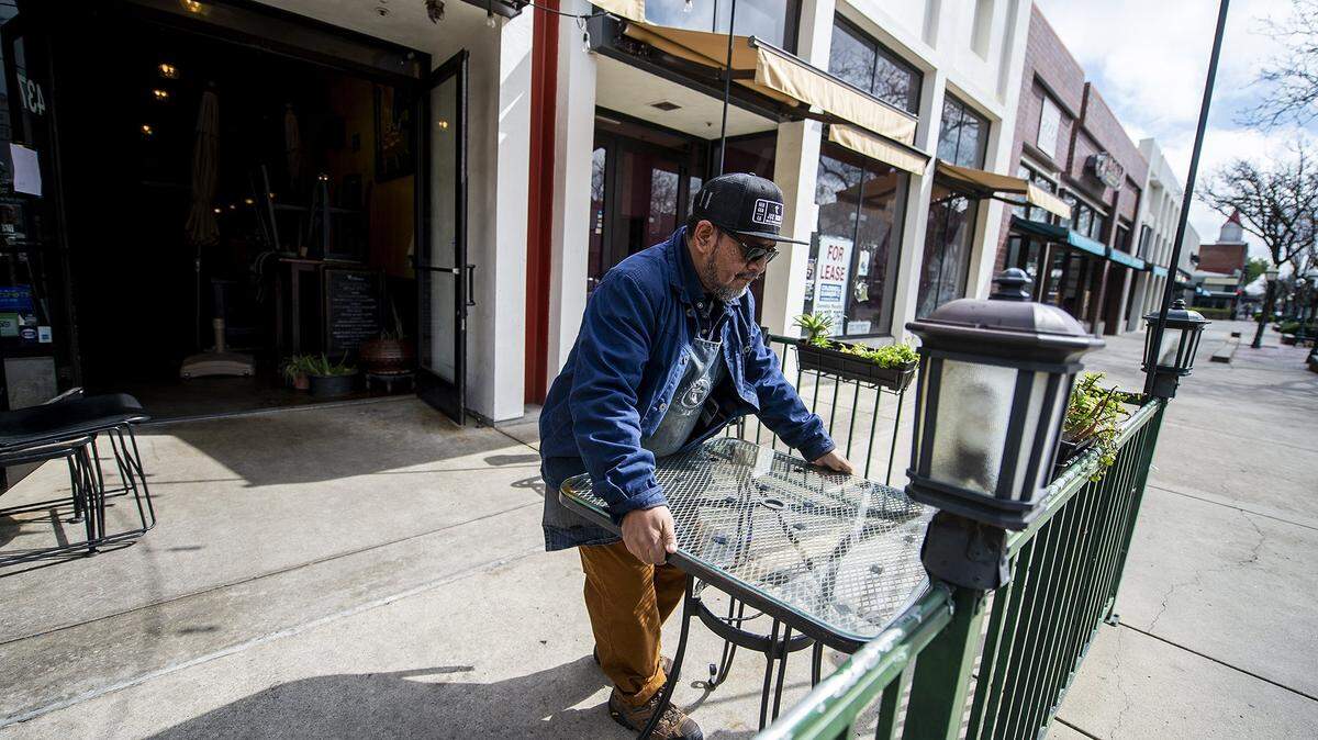 Oscar Torres, co-owner of J&R Tacos sets up tables outside the 437 W. Main Street location in downtown Merced, Calif.