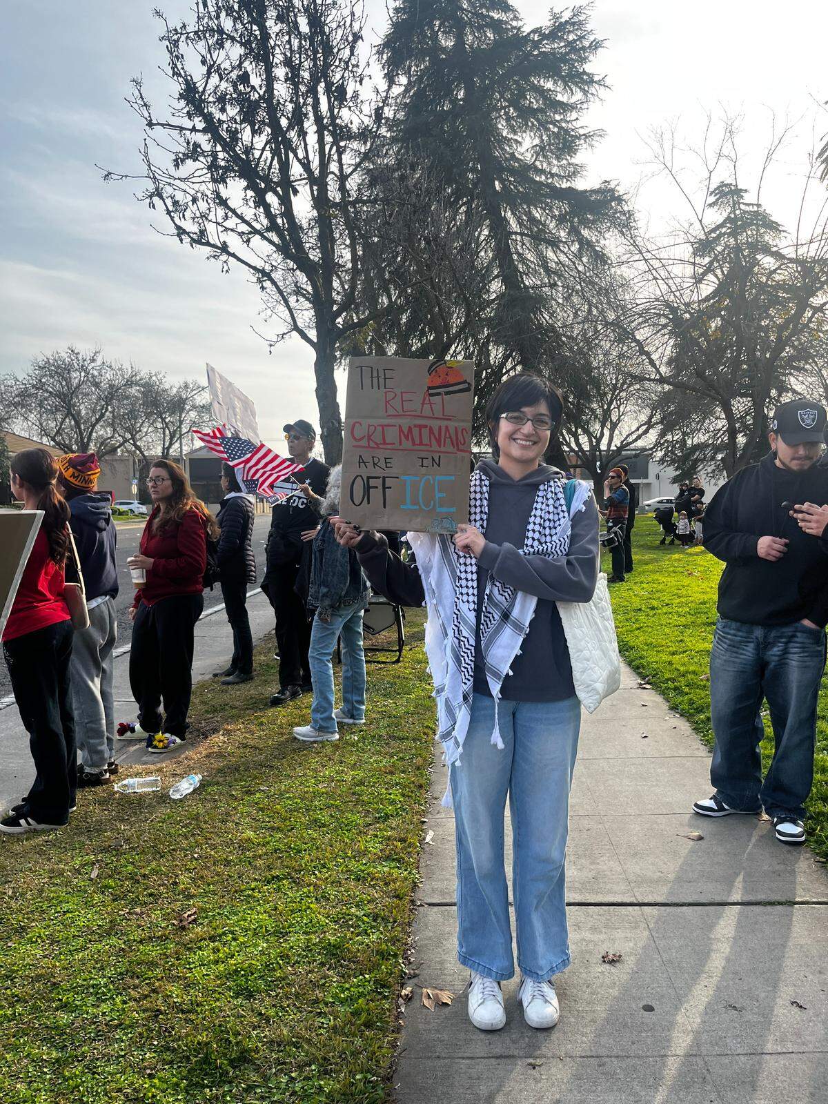 Alejandra Hurtado holds a sign reading “The real criminals are in office.”