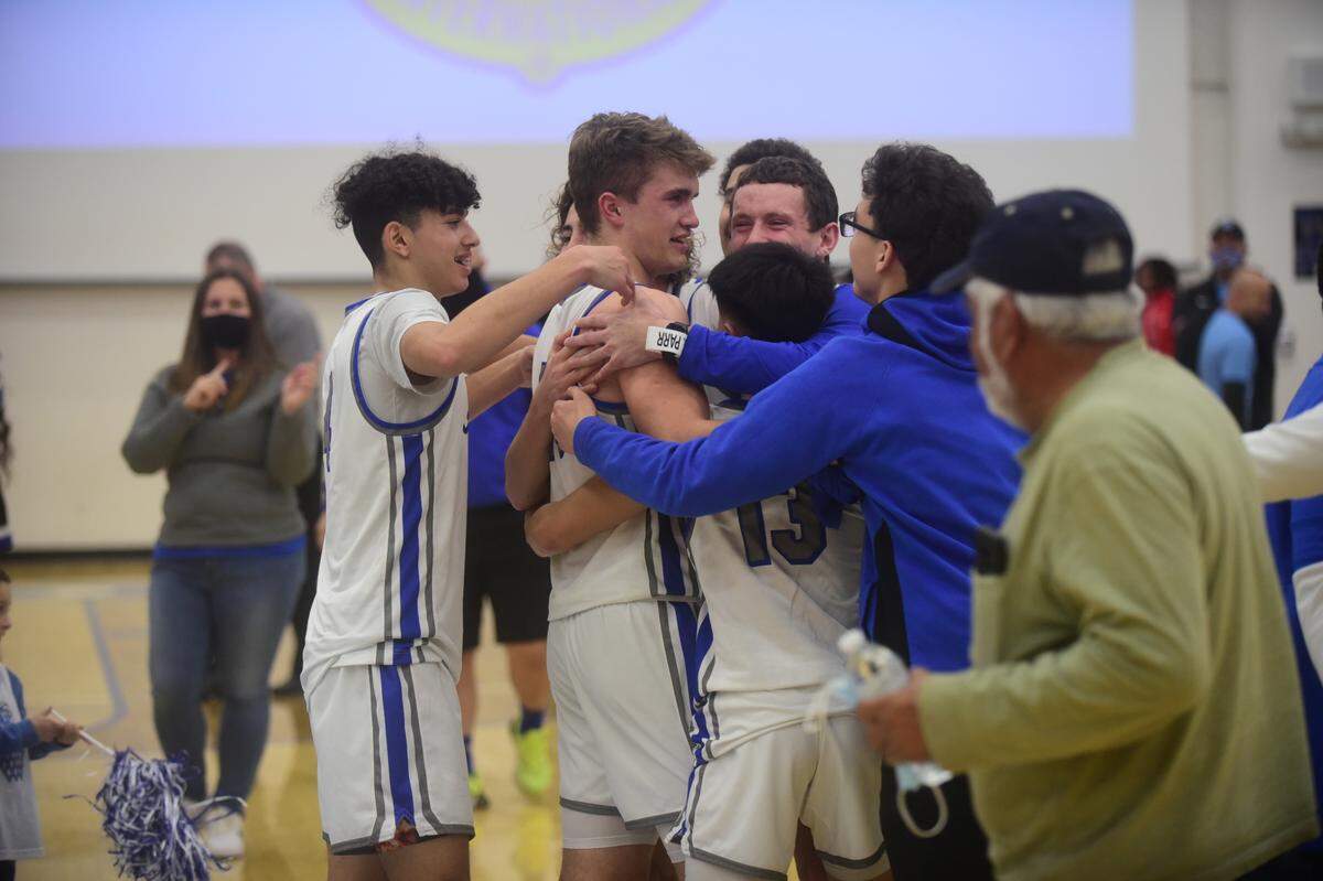 Atwater High players surround Tyler Parr, center, after an emotional 58-53 win over El Capitan on Friday, Feb. 4, 2022, in Atwater. Parr has been playing with a heavy heart after the death of his father, Steve Parr.