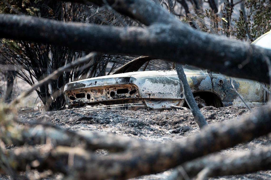 A fire damaged vehicle on a property along Triangle Road in Mariposa County, Calif., as firefighters continue to battle the Oak Fire on Tuesday, July 26, 2022.