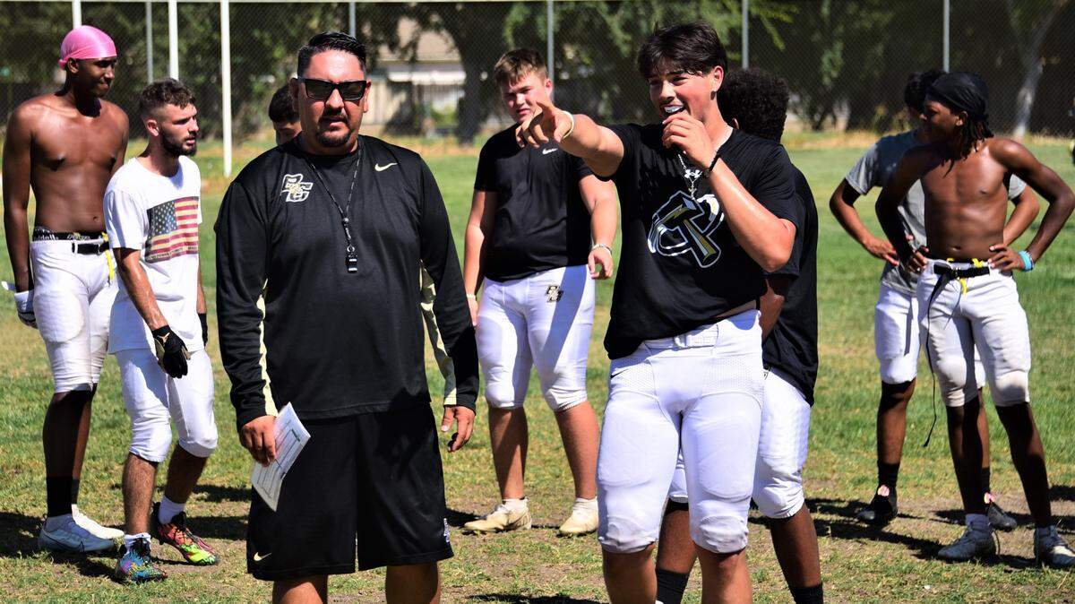 Buhach Colony High School head football coach Matt Granado talks with quarterback PJ Curran during practice on Tuesday, Aug. 15, 2023 in Atwater, Calif.