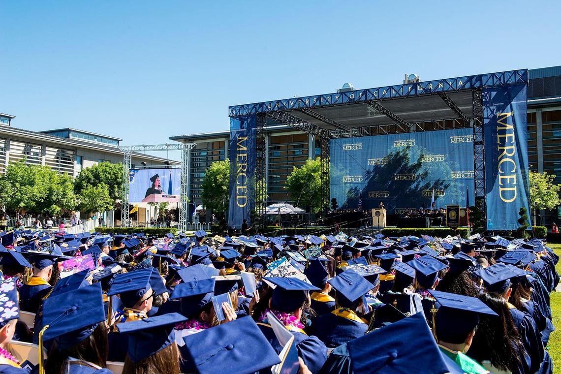 Graduates look on as guest speaker and CNN contributor Maria Cardona speaks during the University of California, Merced School of Social Sciences, Humanities and Arts spring commencement in the Carol Tomlinson-Keasey Quad on the UC Merced campus in Merced, Calif., on Saturday, May 12, 2018.