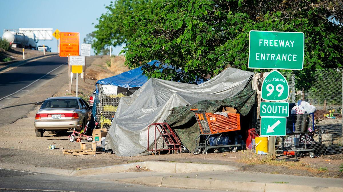 An encampment is seen along the Highway 99 south on-ramp off of G Street in Merced, Calif., on Thursday, May 6, 2021.