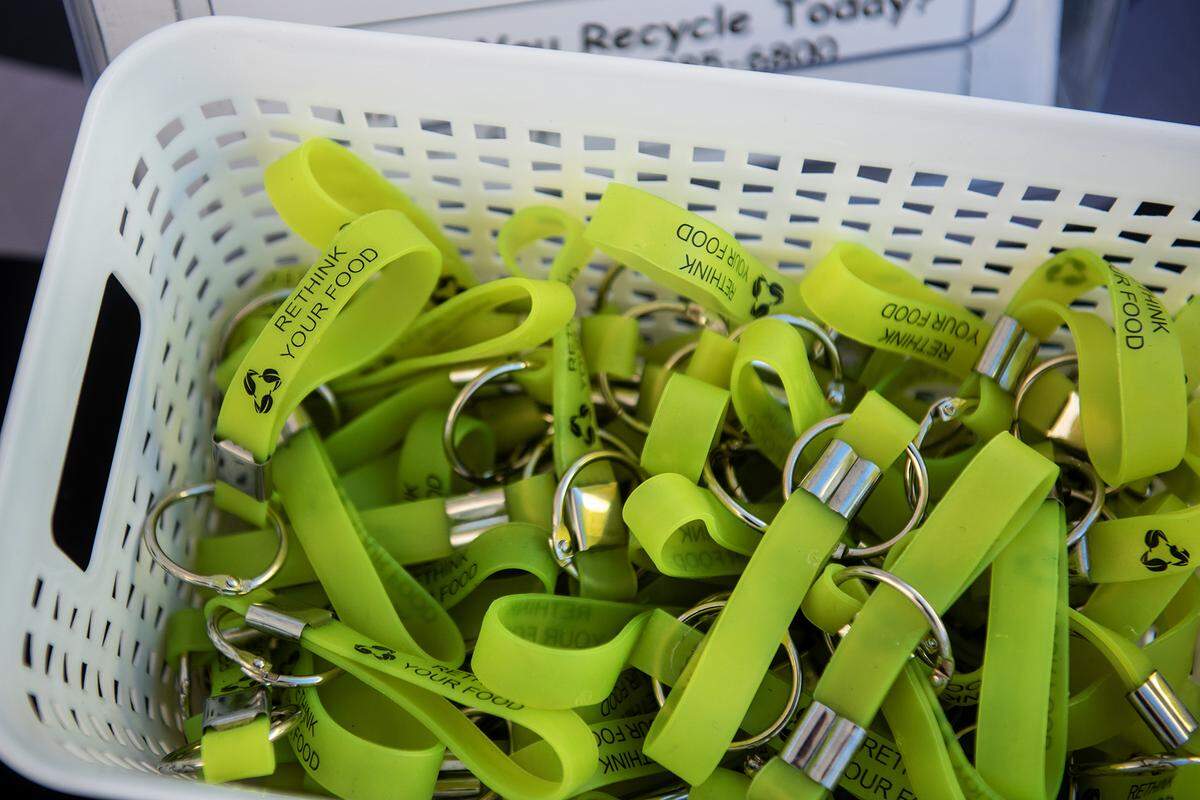 Various give away items with information about recycling sit on the table as City of Merced Recycling Coordinator Monique Gama, interacts with members of the community during the National Night Out event at Applegate Park in Merced, Calif., on Tuesday, Aug. 5, 2025. 