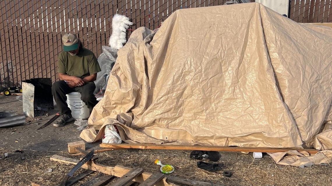 Mike, also known as “Wizard”, sits next to a makeshift shelter by the railroad tracks near 15th Street and Martin Luther King Jr Way on Friday Nov. 1. Two machetes lay near him. He uses the long knives to hack wooden pallets for fires to keep warm at night.