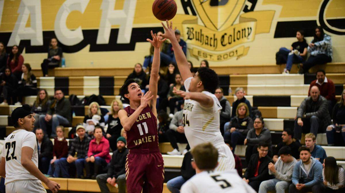 Golden Valley senior Zack Fernandez (11) lofts a shot over Buhach Colony center Gerald Braxton during a game on Friday, Jan. 17, 2020 at the Thunder Dome at Buhach Colony High School.