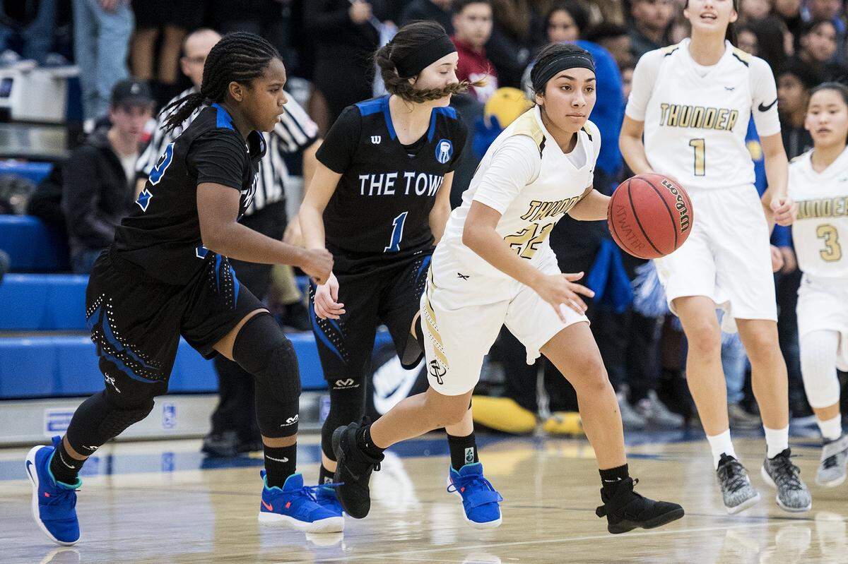 Buhach Colony junior Cassandra Gutierrez (22) gets past Atwater sophomore Amoni Claiborne (32) and senior Kelsey Valencia (1) during a game at Atwater High School in Atwater, Calif., on Thursday, Jan. 17, 2019.