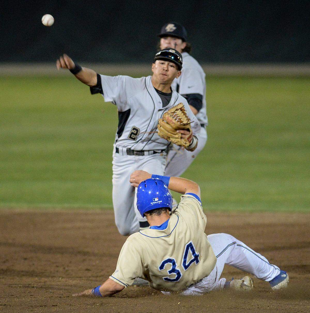 Buhach Colony’s Daniel Casso, center, throws to complete a double-play after forcing out Clovis High’s Koby Kropf during the championship game of the Fresno Easter Classic at Clovis West on Wednesday, April 17, 2019. 