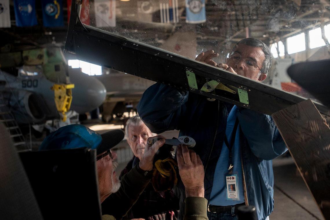 United States Air Force veteran Marcelo Paz, 69, of Chowchilla, right, works on a Bell AH-1W Cobra attack helicopter while fellow Air Force veterans John Hogrefe, 71, of Modesto, left, and John de Jong, 80, of Modesto, rear, assist and look on inside Castle Air Museum’s restoration hanger in Atwater, Calif., on Wednesday, Jan. 12, 2022. According to Castle Air Museum Chief Executive Director Joe Pruzzo, the Bell AH-1W Cobra attack helicopter and a SH-60B Seahawk helicopter were acquired from Hawaii in 2021. When ready, the aircraft will be displayed on the Castle Air Museum grounds along with dozens of other vintage aircraft.