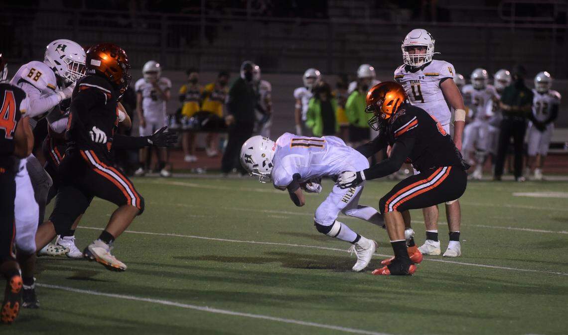 Merced High defender Jalonn Booth wrestles down Hilmar running back Cannon Irelan during the Bears’ 14-13 win on Friday, April 2, 2021 at Veteran Stadium in Merced, Calif.
