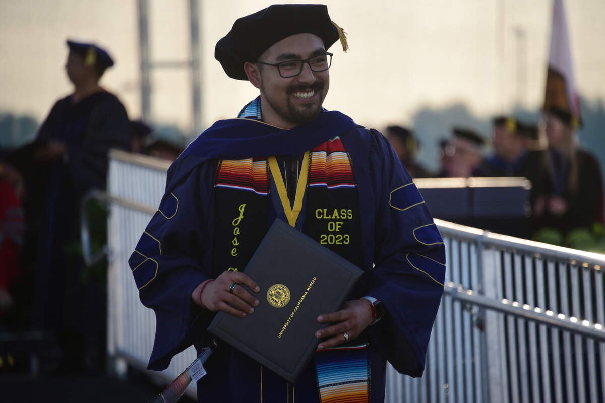 UC Merced graduate student Jose Zamora makes his way down the stage after receiving his Ph. D in Materials and Biomaterials Science and Technology during UC Merced’s spring commencement ceremony on Friday, May 12, 2023.