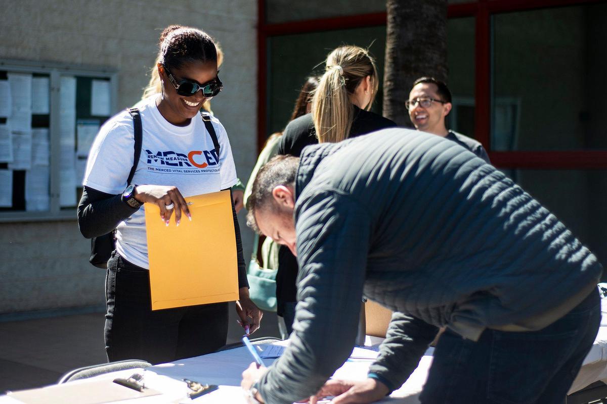 Volunteer Ruthie Dickerson, 41, of Merced, left, assists those signing the petition to renew Measure C during the Committee for a Safer Merced kickoff rally for to renew Measure C outside the Merced Civic Center in Merced, Calif., on Thursday, April 13, 2023. The half-cent sales tax was approved in 2006 and funds more than 30 public safety positions as well as providing resources for emergency responses and road improvements. The measure is set to expire in 2026.