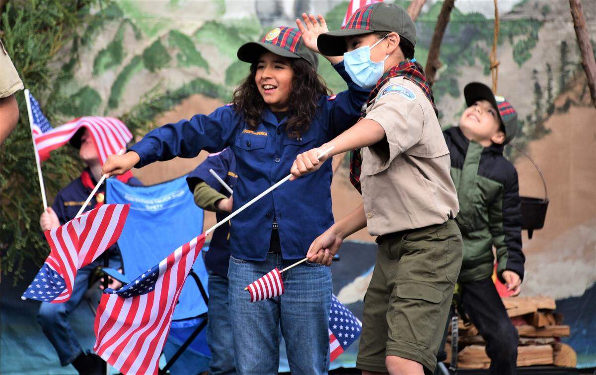 Members of Cub Scouts Pack 96 in Merced wave to people as they drive through the Veterans Day Parade on Thursday, Nov. 11, 2021 in downtown Merced, Calif.