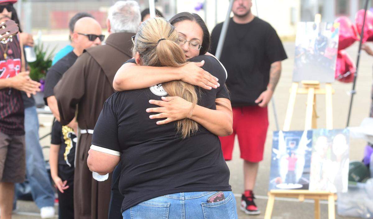 Mireya Rodriguez receives a hug during a candlelight vigil for her son Oscar Xavier Rodriguez, 15, held at Golden Valley High School in Merced, Calif. on Friday, Aug. 3, 2024. Oscar Xavier Rodriguez was struck and killed by a vehicle while riding his bike home on July 25, 2024.