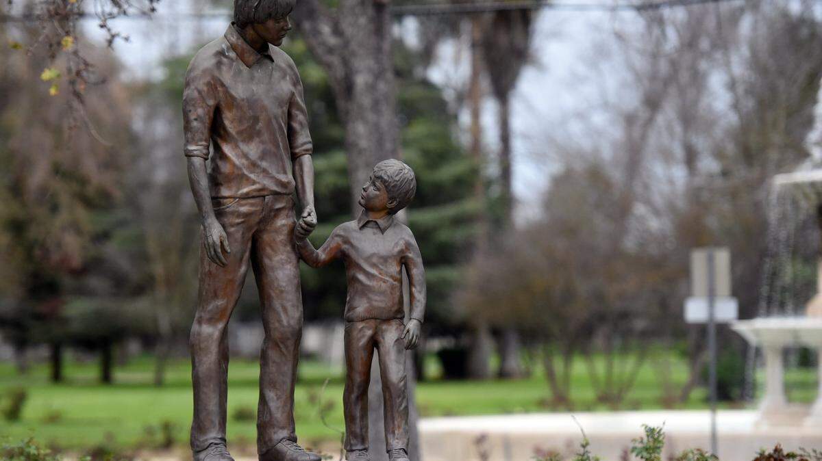 The “Teen Hero” statue, erected in honor of kidnapping victim Steven Stayner, stand near the rosebushes in the Merced community rose garden in Applegate Park on Wednesday, Feb. 17, 2016. The city will look to replace turf in the area to make the garden more water efficient.