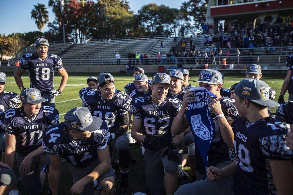 Stone Ridge Christian players take turns kissing the banner after defeating Big Valley Christian 69-0 in the Sac-Joaquin Section Division VII championship at Lincoln High School in Stockton, Calif., Saturday, Nov. 28, 2015. The Knights won back-to-back section titles under DeJager in 2014 and 2015.