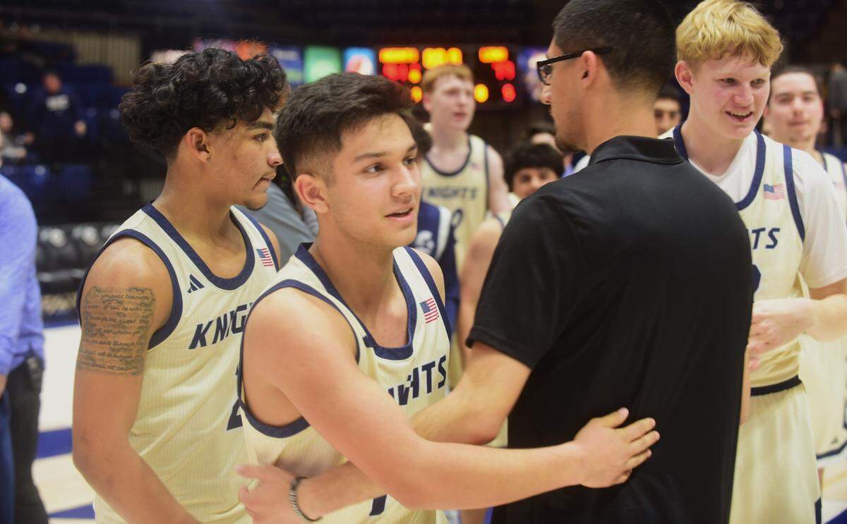 Stone Ridge Christian junior Kassius Salazar (15) celebrates with teammates and coaches after the Knights defeated Valley Christian 91-77 to win the Sac-Joaquin Section Division VI championship at UC Davis on Friday, Feb. 23, 2024.