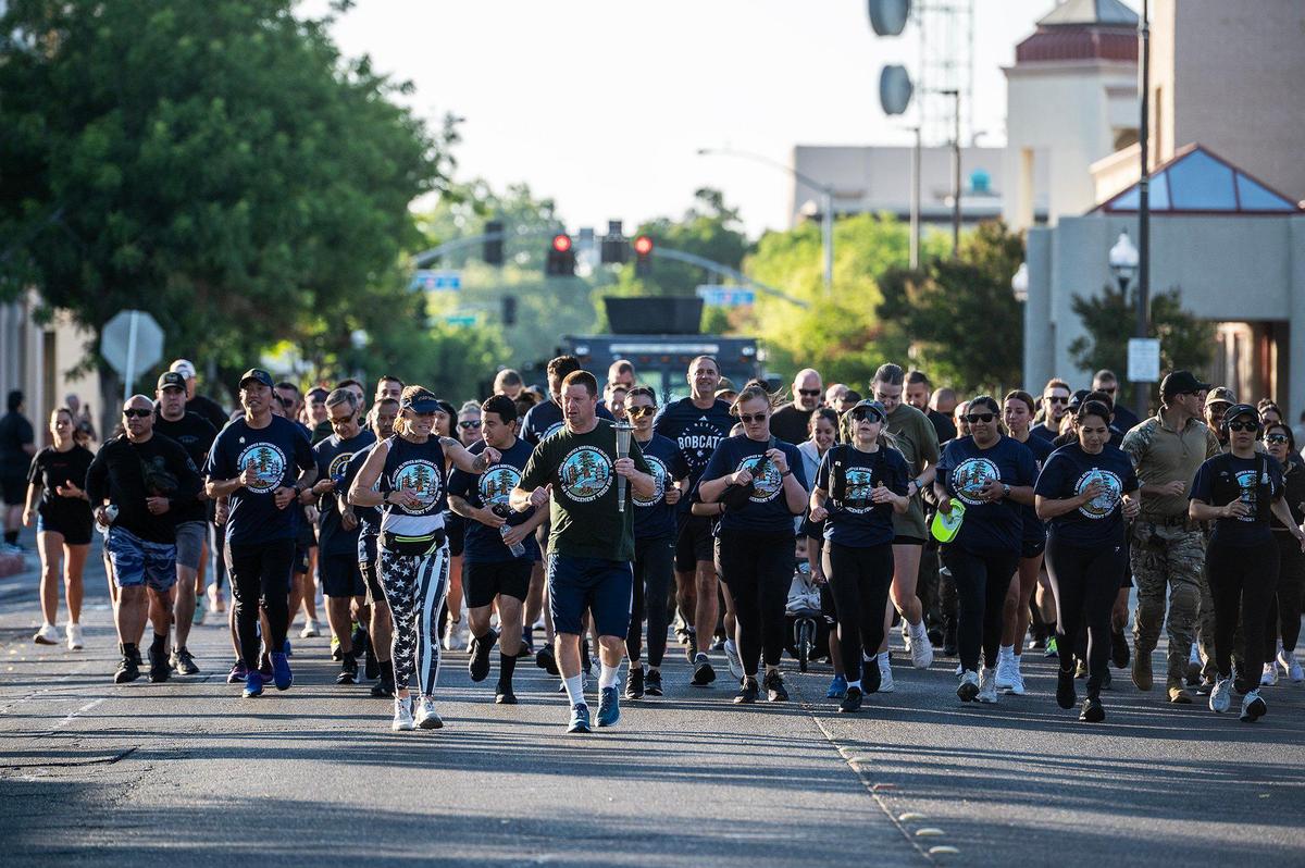 Merced resident and Special Olympics athlete Mark Heffner, 43, leads a pack of runners along West 18th Street while carrying the torch with the “Flame of Hope” during the annual Law Enforcement Torch Run for Special Olympics Northern California in Merced, Calif., on Wednesday, June 25, 2025.