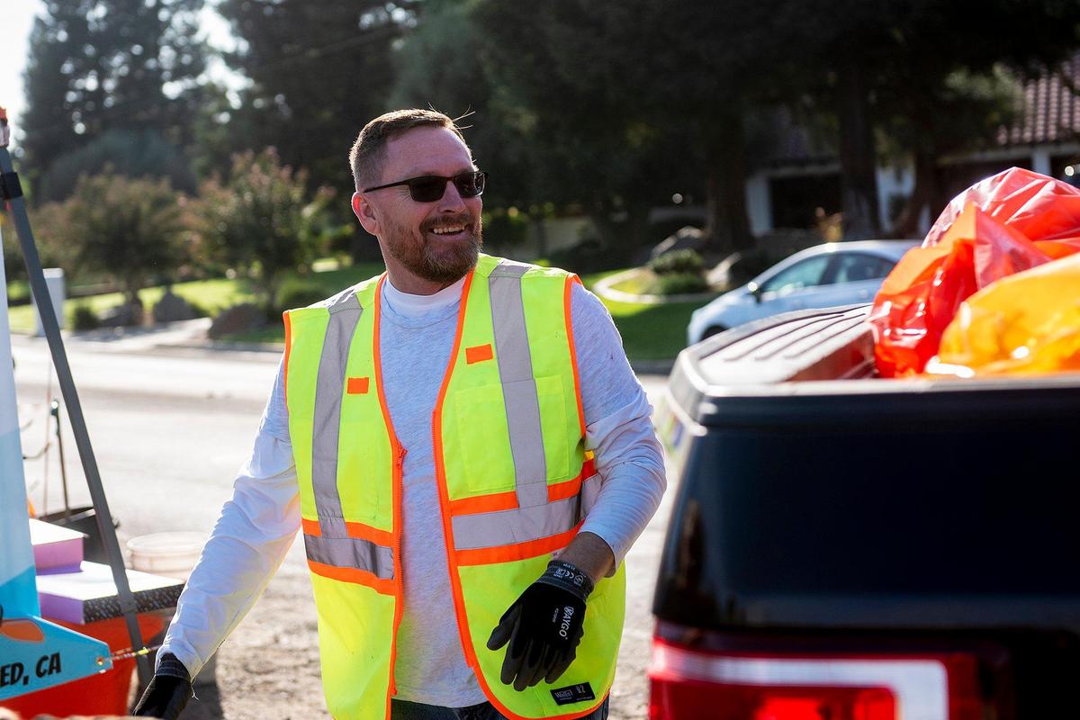 Jeremiah Greggains, 49, co-founder and vice president of the Merced non-profit Bear Creek Yacht Club, places trash collected from the banks of Bear Creek into the bed of a pickup truck during a cleanup event in Merced, Calif., on Saturday, Oct. 14, 2023.