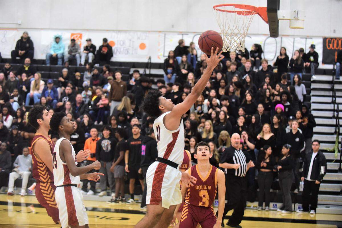 Merced High School senior John Simpson (11) goes up for a basket during a game against Golden Valley on Friday, Jan. 20, 2023 at Merced High School.
