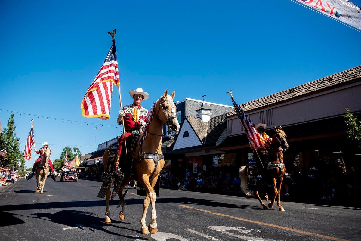 Members of the Merced County Sheriff Posse make their way along Broadway Avenue during a Fourth of July parade in Atwater, Calif., on Monday, July 4, 2022.