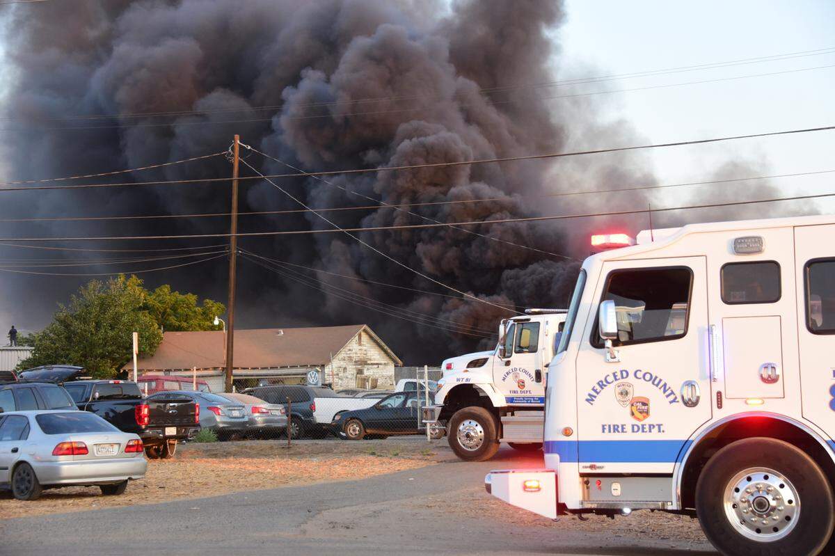 Firefighters from Merced County, Merced City and Atwater City fire departments teamed up to battle a blaze at two Merced auto yards on East Childs Ave. on Friday, July 9, 2021.