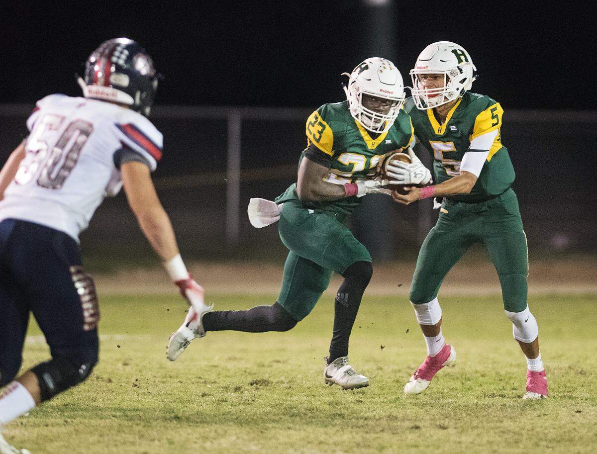 Hilmar’s Issac Sharp takes a handoff from quarterback Treven Crowley during the Trans Valley League game in at Hilmar High School in Hilmar, Calif., on Friday, Oct. 12, 2018. Modesto Christian won the game 24-21.