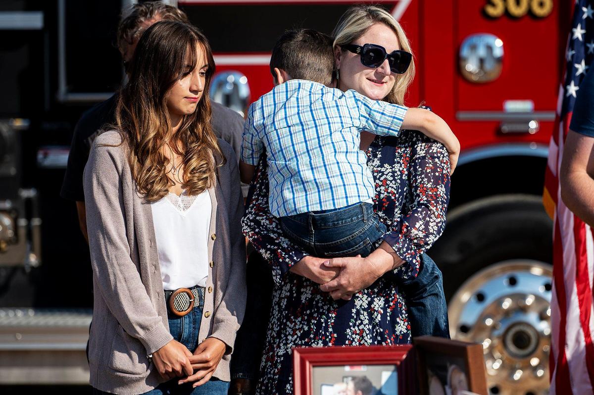 Jennifer Rotondaro, a la derecha, sostiene a su hijo Wyatt, de cinco años, con su hija, Kiersten, de 17 años, a la izquierda, durante la ceremonia de dedicación de un tramo de la Highway 140 cerca de Gustine para su difunto esposo y capitán de Cal Fire Paul Vincent Rotondaro, en el condado de Merced, California, el lunes 18 de septiembre de 2023. Rotondaro murió en una colisión de tránsito mientras estaba de servicio en el condado de Merced el 2 de octubre de 2019.