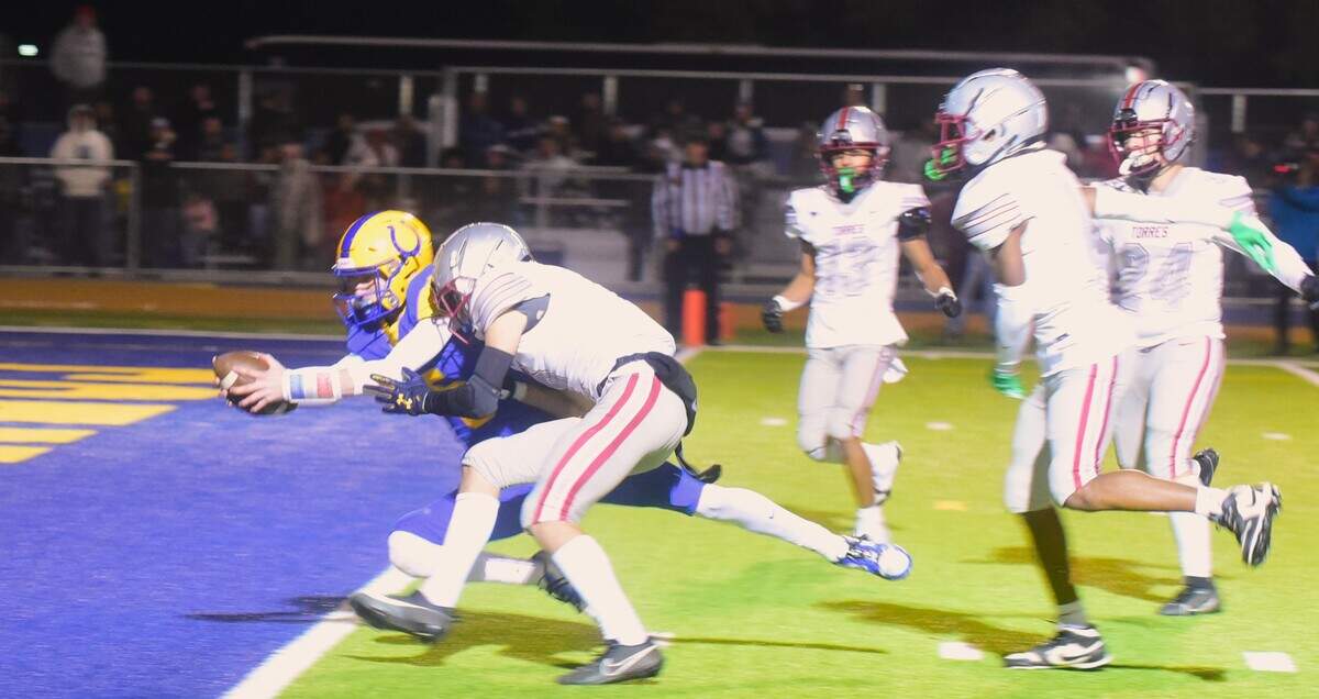 Dos Palos High School senior quarterback Peyton Van Worth dives for the end zone to score on a 23-yard run during the first half against Torres in the Central Section Division IV championship game on Friday, Nov. 24, 2023.