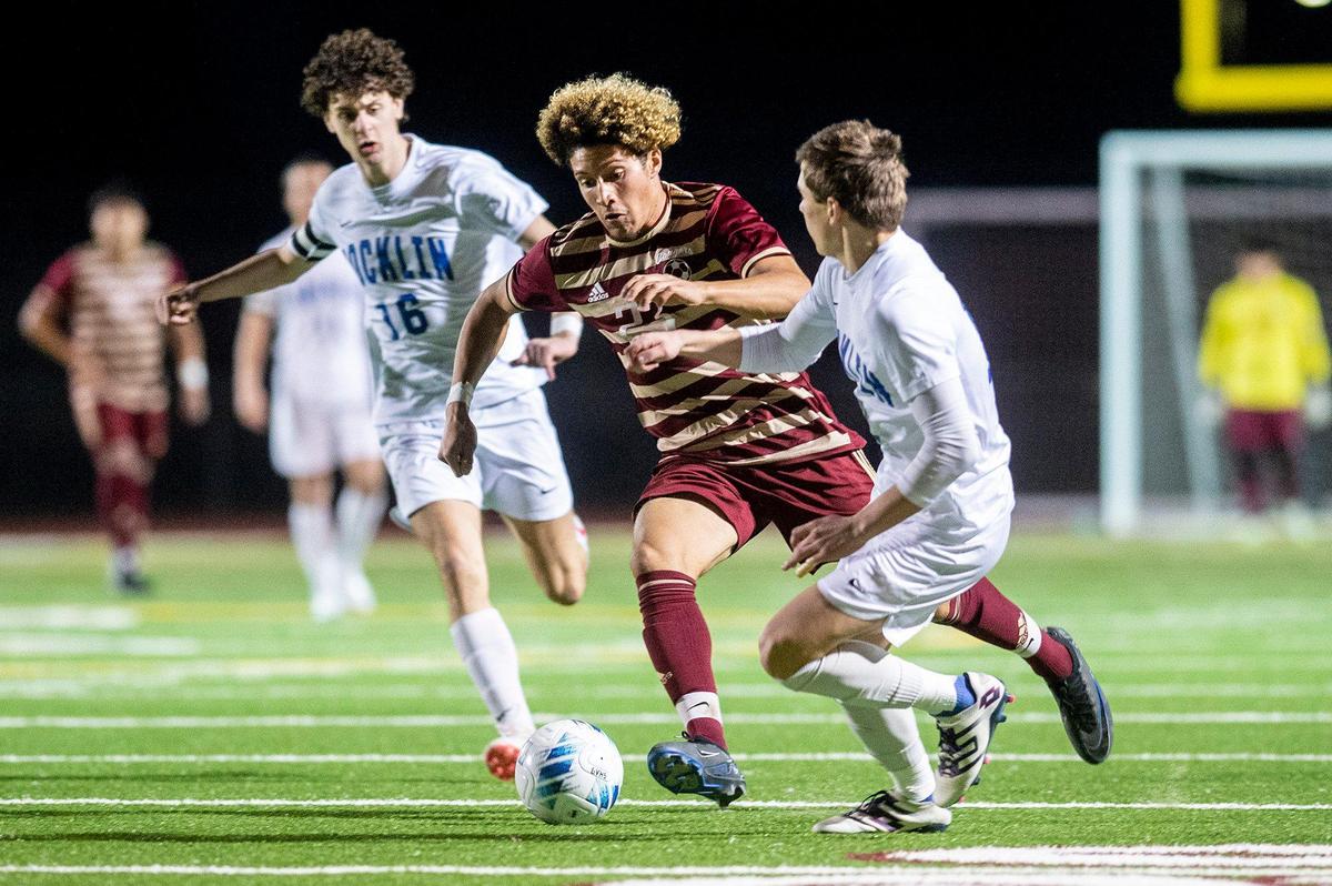Golden Valley senior Malachi Wright (23) dribbles between two Rocklin defenders during a Division 2 playoff game at Golden Valley High School in Merced, Calif., on Tuesday, Feb. 13, 2024. The Cougars beat the Thunder 3-0.