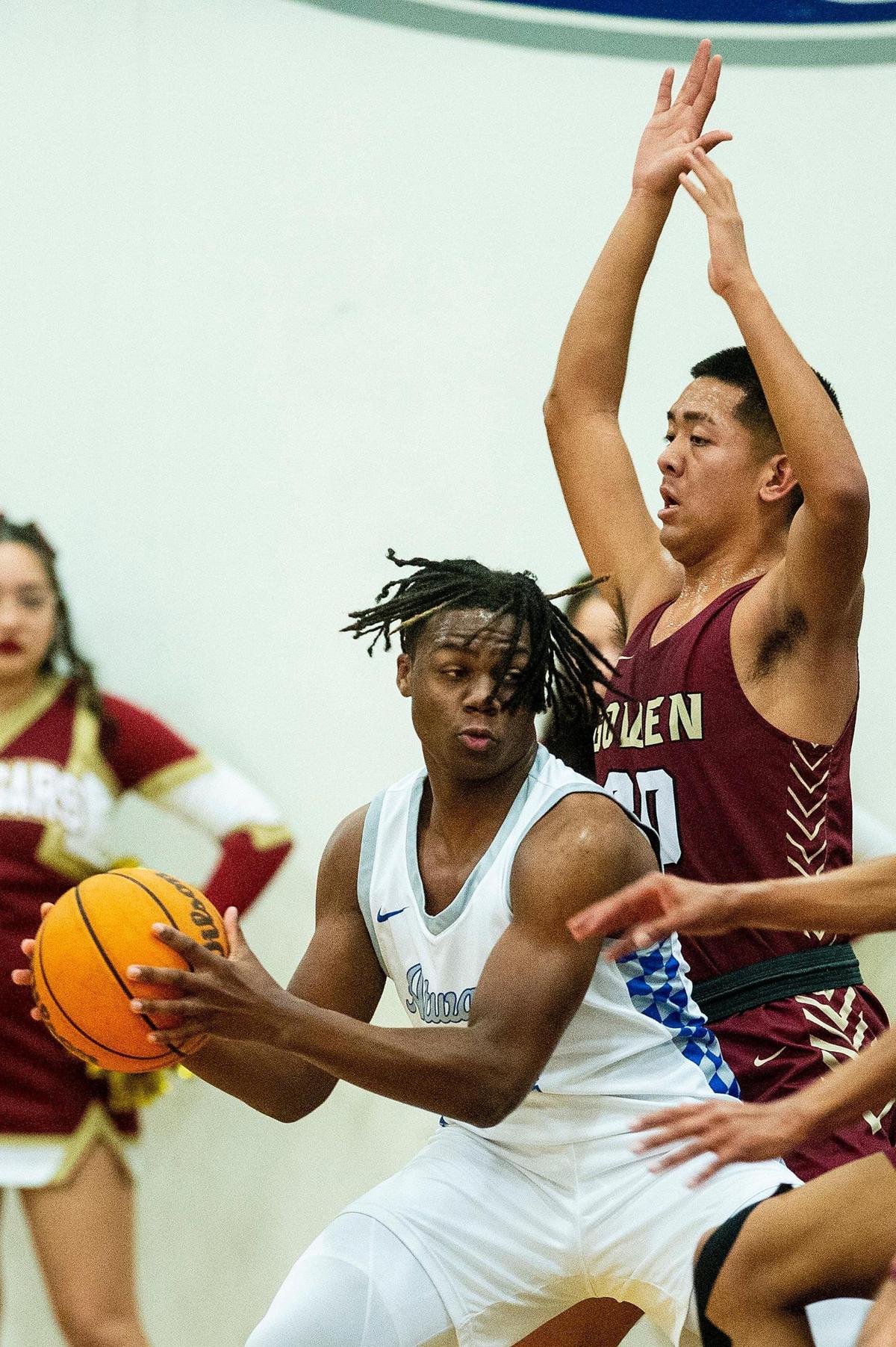 Atwater sophomore Ali Banks Jr. (4) attempts to spin around Golden Valley junior Jeff Tangaan (30) during a game at Atwater High School in Atwater, Calif., on Monday, Jan. 29, 2024.