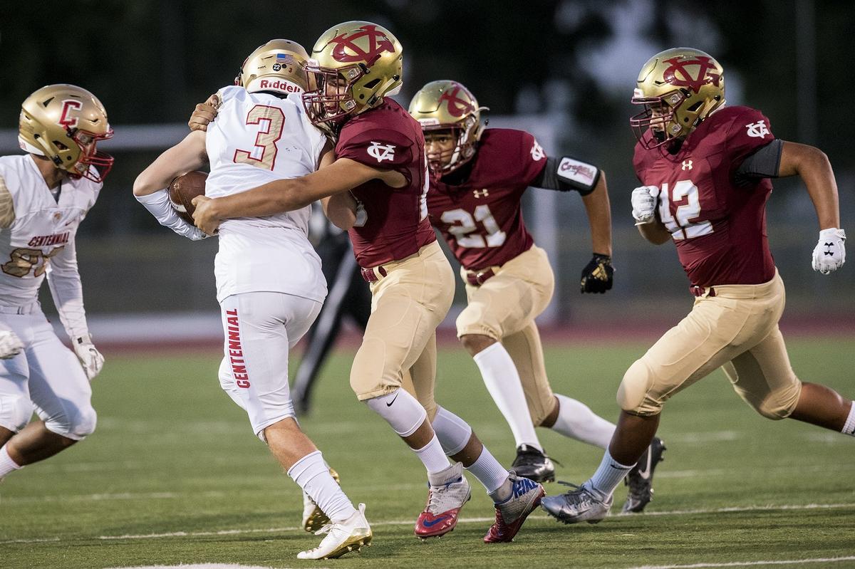 Golden Valley senior Israel Robles (23) tackles Centennial senior Hudson Sabol (3) during a game at Veterans Stadium on the campus of Golden Valley High School in Merced, Calif., on Friday, Aug. 31, 2018. The Golden Hawks beat the Cougars 38-15.