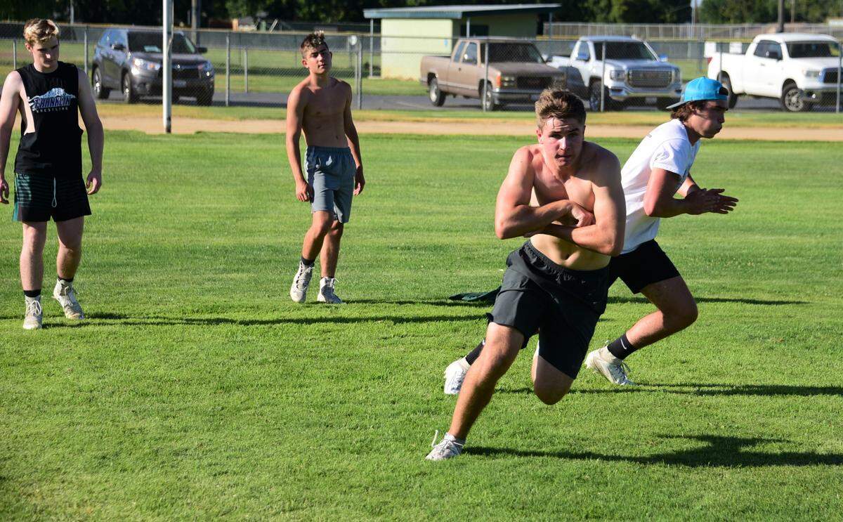 Hilmar High senior Cole Bailey follows through on a running play during a football workout without equipment or balls at Hilmar High School on Wednesday, June 10, 2020.