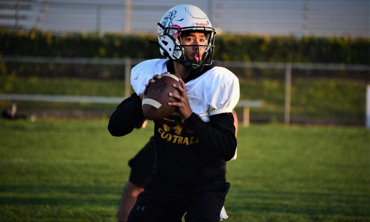 Le Grand High junior Juilan Bucio drops back to pass during practice on Wednesday, Dec. 1, 2021 at Le Grand High School in Le Grand, Calif.