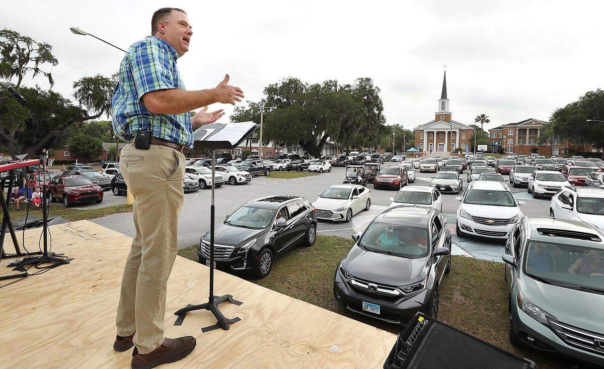 Pastor Cliff Lea preaches over a parking lot filled with cars during a drive-in service at the First Baptist Church of Leesburg, Florida, on Easter Sunday, April 12, 2020. Drive-in assemblies are one of the few options for congregations in California counties on the state’s watch list.