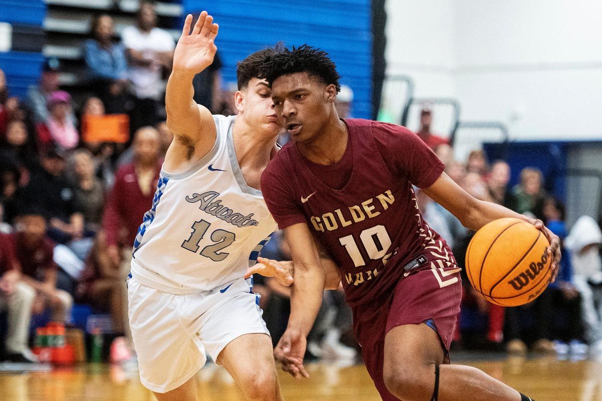 Golden Valley sophomore Izaivian Goode (10) dribbles past Atwater junior Landon Perez (12) during a game at Atwater High School in Atwater, Calif., on Monday, Jan. 29, 2024.