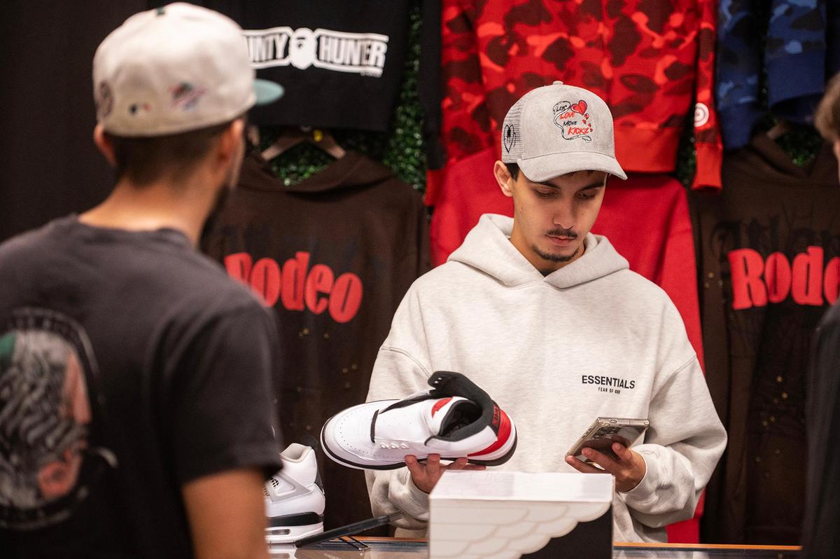 Store manager Alex Hernandez, 20, of Stevinson, right, assists a customer who brought in a pair of shoes at The Come Up Kickz located inside the Marketplace at Merced in Merced, Calif., on Friday, May 16, 2025. The business sells, buys and trades merchandise such as sneakers, collectibles, designer items and clothing.