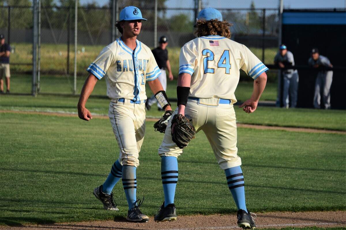 El Capitan High senior pitcher Carson Viera (2) is greeted by third baseman Dyland Rogers (24) after Viera threw a complete game in a 6-2 win over Buhach Colony on Friday, April 8, 2022 at El Capitan High School in Merced, Calif.