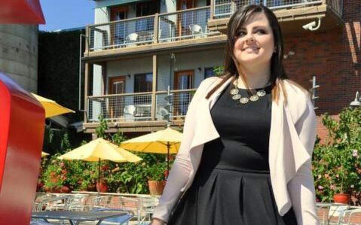  A black dress with pleats and pockets is dressed up with a blush-colored cover-up and sparkly necklace. 
