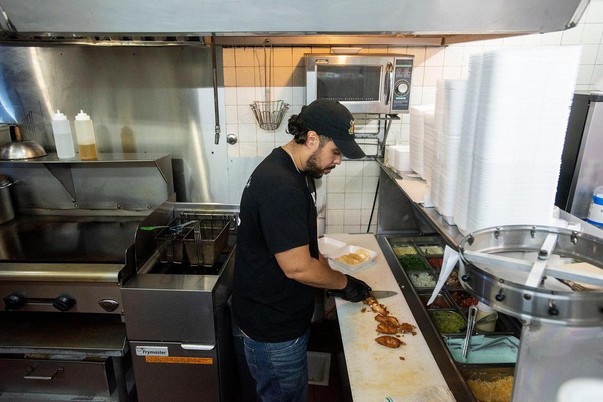Chayanne Valencia, 33, prepares an order fish tacos at Maria’s Taco Shop in Merced, Calif., on Tuesday, Oct. 15, 2024. The restaurant which is open 24 hours, has offered authentic fast Mexican food to the Merced community for 32 years.